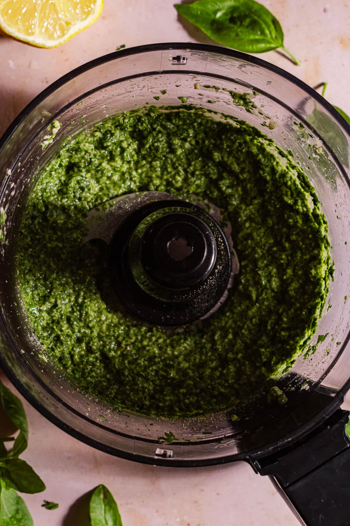 A food processor with blended pesto.