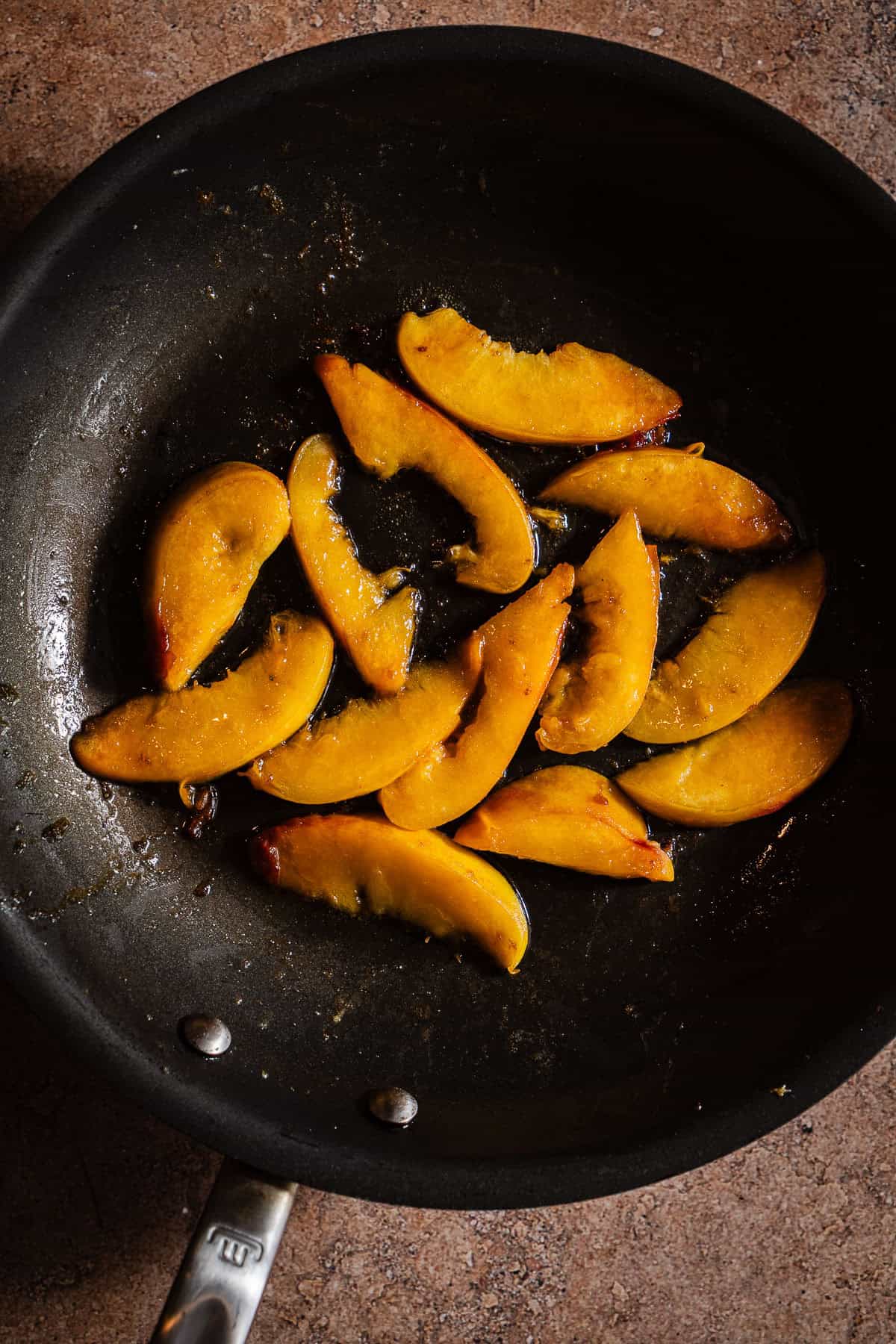 Sliced peaches in a frying pan.