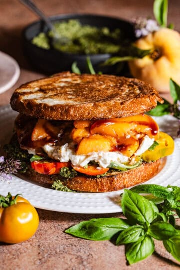 A grilled sandwich with peaches, burrata, and pesto.
