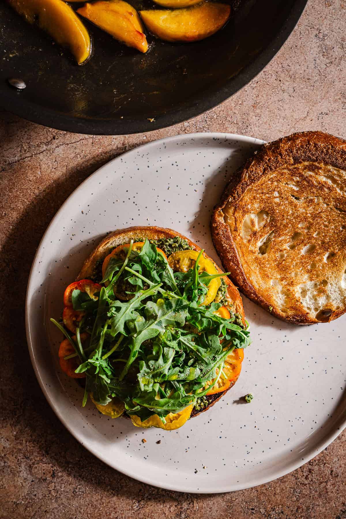 Grilled sourdough topped with pesto, tomatoes, arugula, and sauteed peaches.