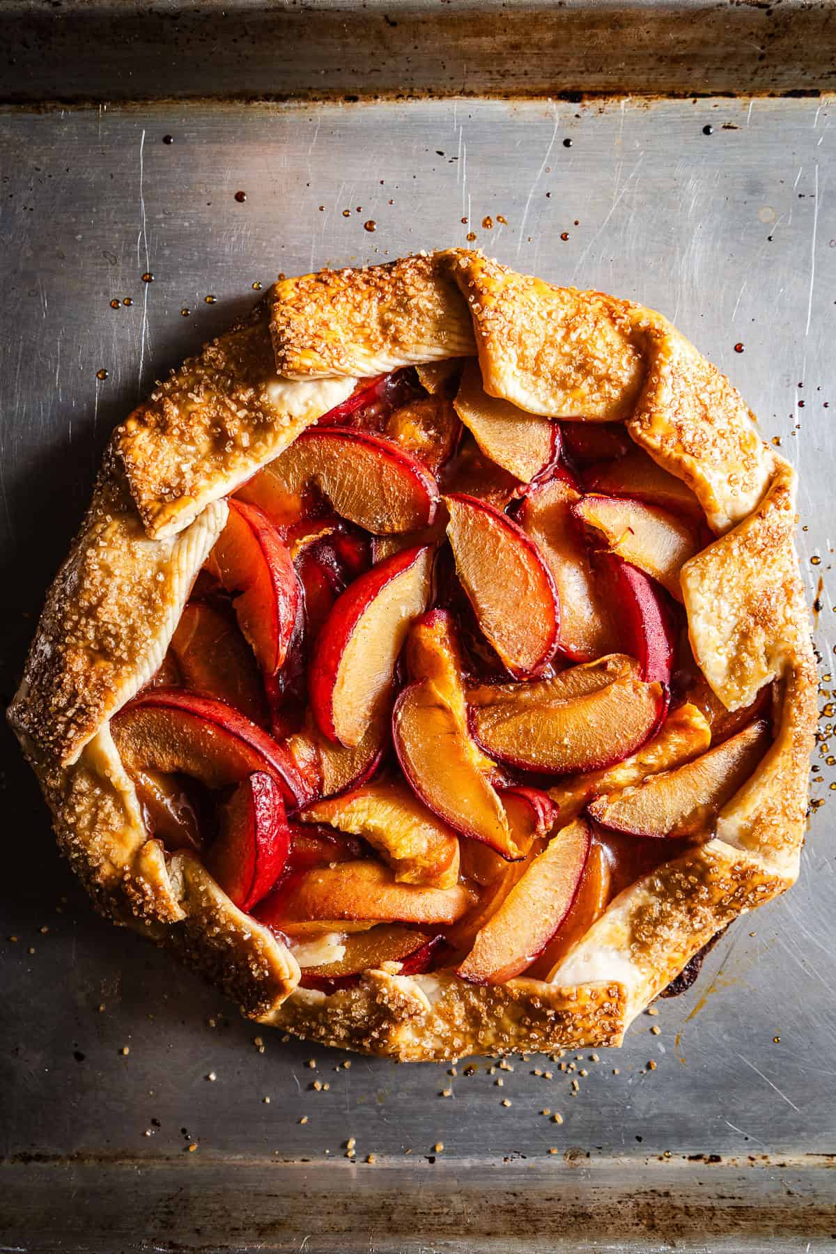 A baked galette with plums and peaches on top.