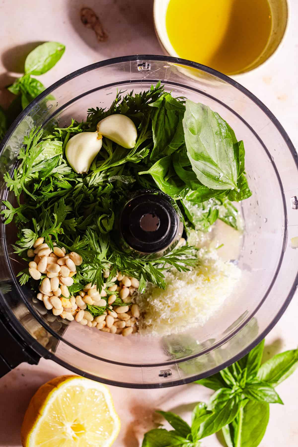 A food processor full of the ingredients for carrot top pesto.