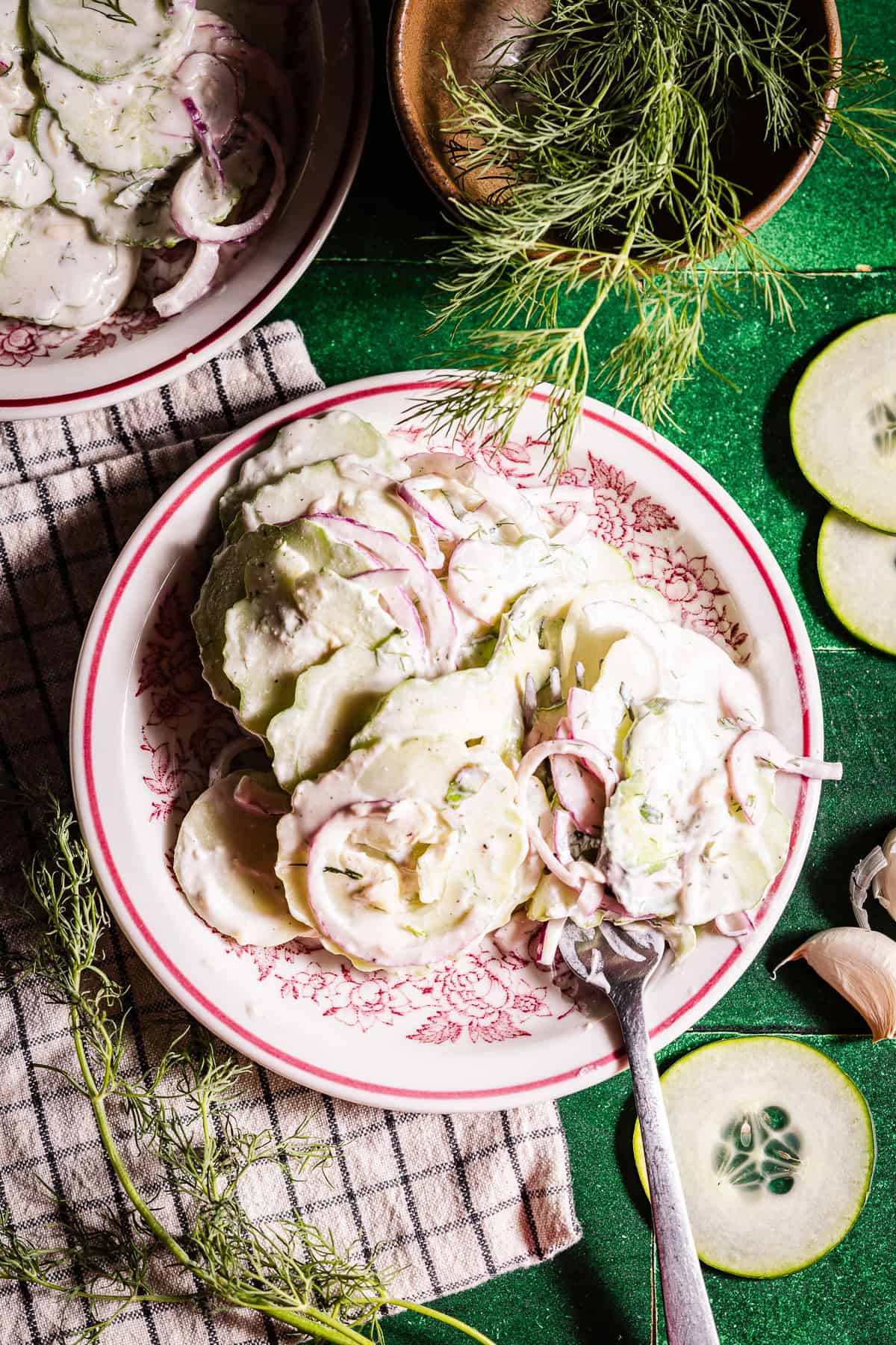 Creamy cucumber salad in side plates with a fork for eating.