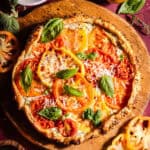 Herby goat cheese tomato galette topped with basil and parmesan cheese.