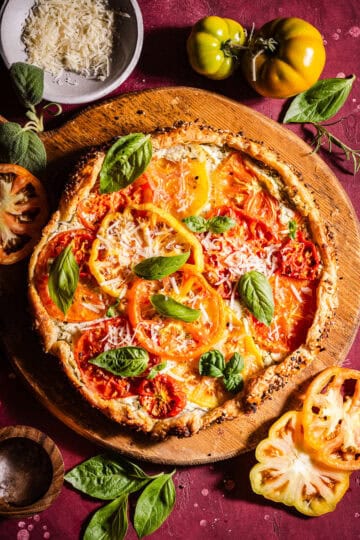 Herby goat cheese tomato galette topped with basil and parmesan cheese.