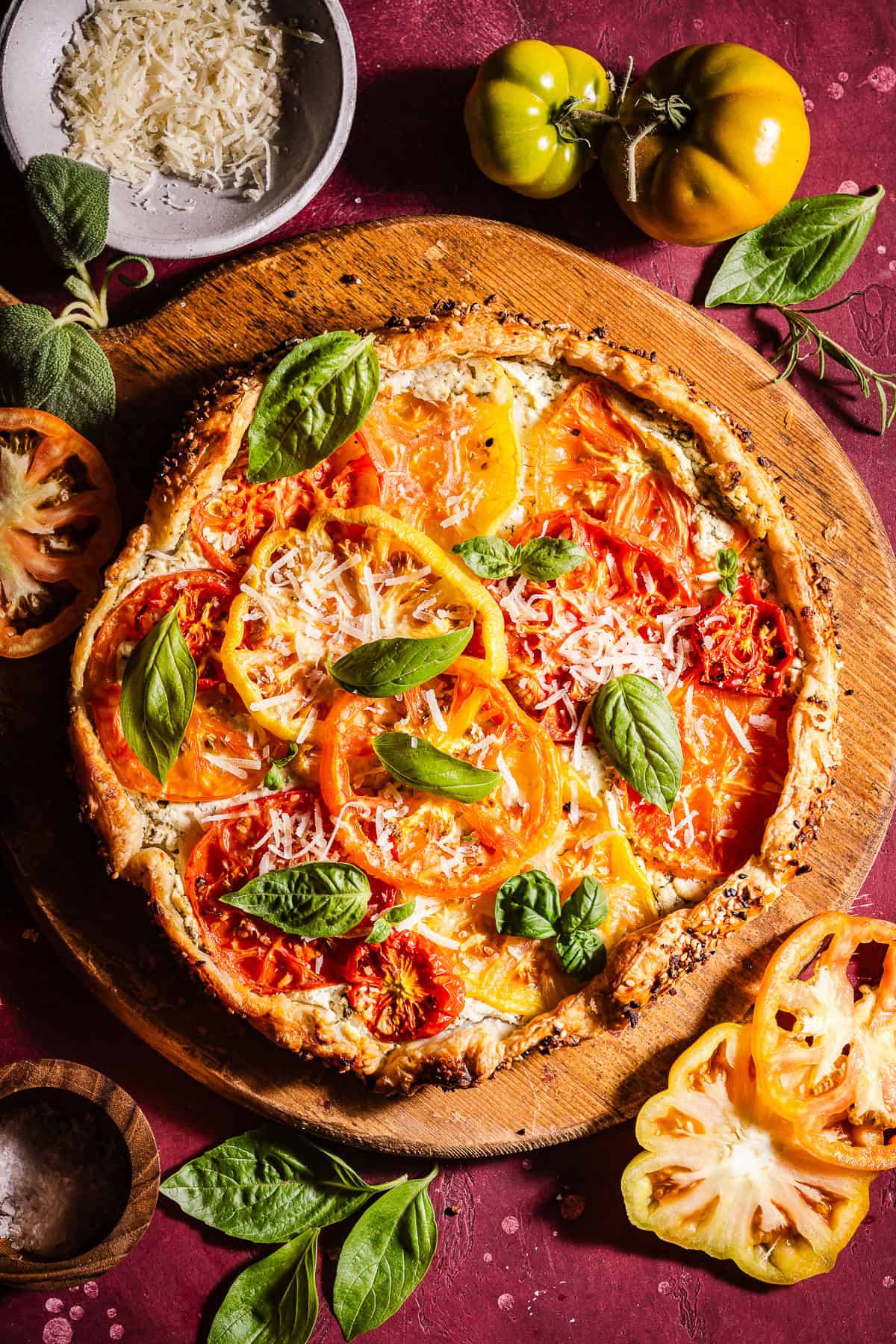 Herby goat cheese tomato galette topped with basil and parmesan cheese.