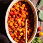 Tomato Confit in a baking dish with a being spooned.