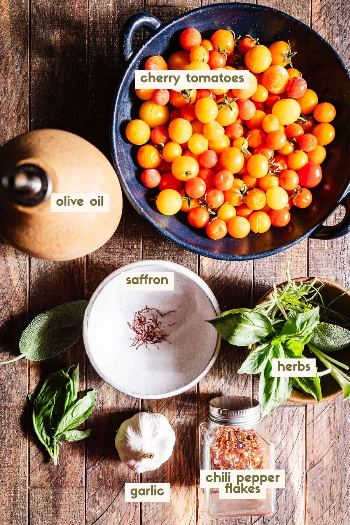 cherry tomatoes, olive oil, saffron, herbs, chili pepper flakes, garlic ingredients with labels.