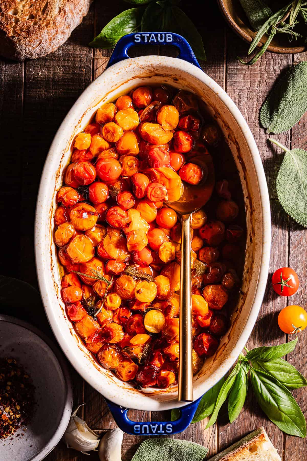 Tomato Confit in a baking dish with a being spooned.
