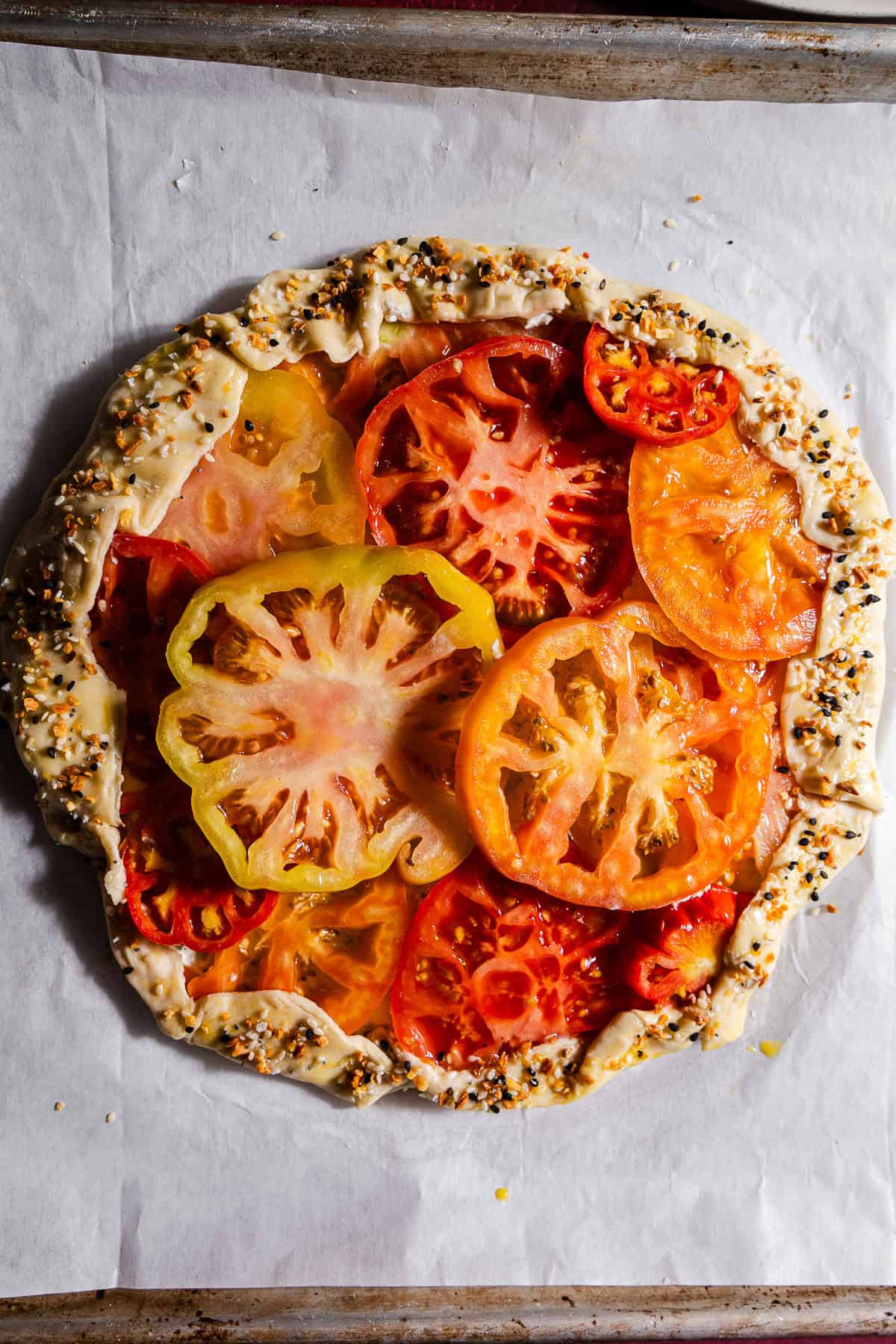 Unbaked tomato galette in a sheet pan.