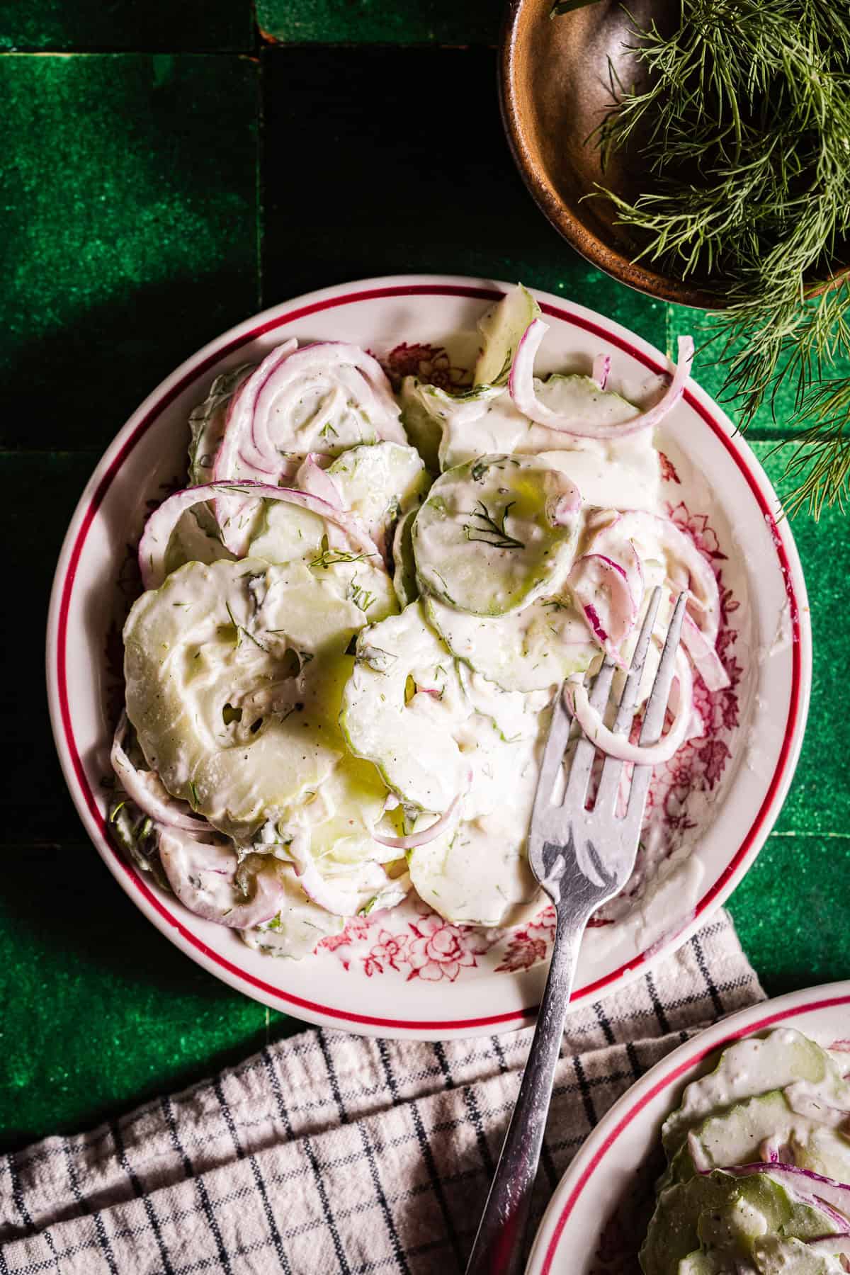 Creamy cucumber salad in side plates with a fork for eating.